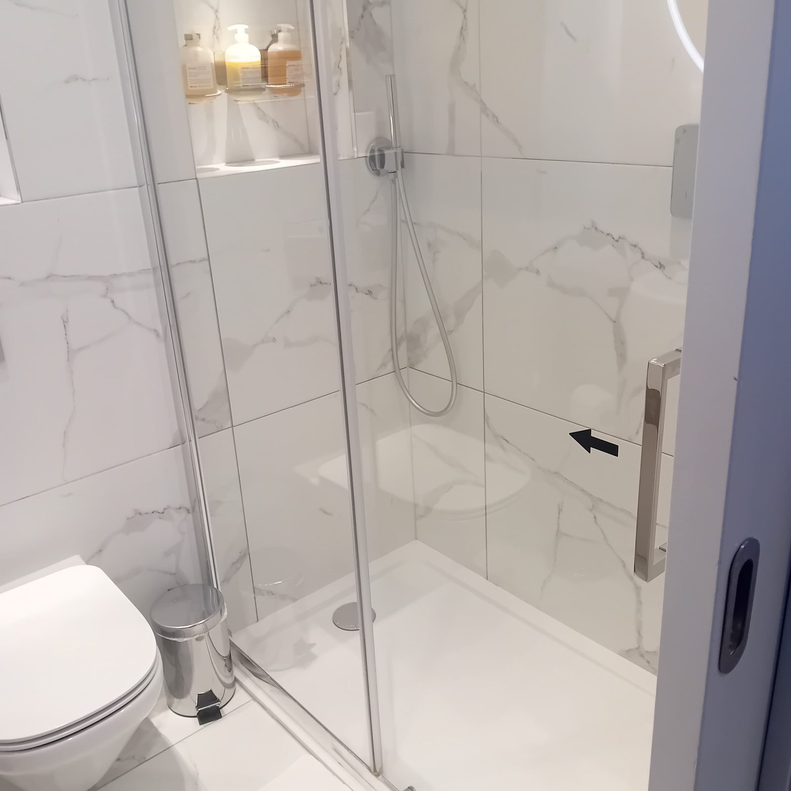 Freshly cleaned marble-tiled shower room in a London Airbnb